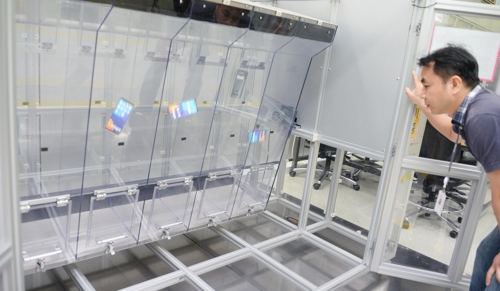 ▲ LG전자 연구원이 약 1m 높이의 투명한 사각 통에 LG G6를 넣고 끊임없이 회전시키는 '연속 낙하 시험'을 실시하고 있다. 이는 소비자가 스마트폰 사용 중에 접할 수 있는 일상적 충격에 대비한 것이다. [LG전자 제공]