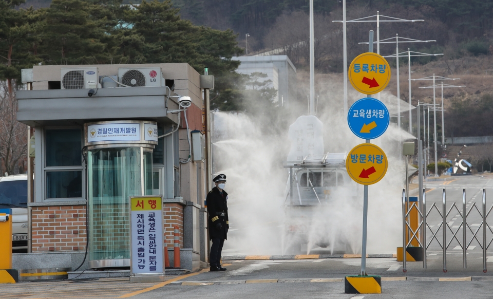 사진 = 30일 오후 충남 아산시 초사동 경찰인재개발원정문에 들어가는 차량에게 소독을 하고 있다. 연합뉴스