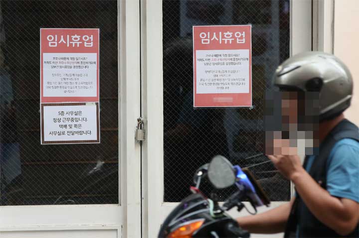 사진 = '사회적 거리 두기 2.5단계'가 시행되고 있는 31일 오후 서울의 한 카페에 '코로나19 확산방지를 동참을 위한 임시휴업 안내문'이 붙어 있다. 연합뉴스