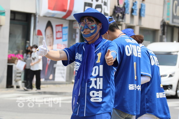 ▲한 후보의 선거사무원이 보디 페인팅을 하고 지나가는 차들을 향해 춤을 추고 있다. 김정기 기자