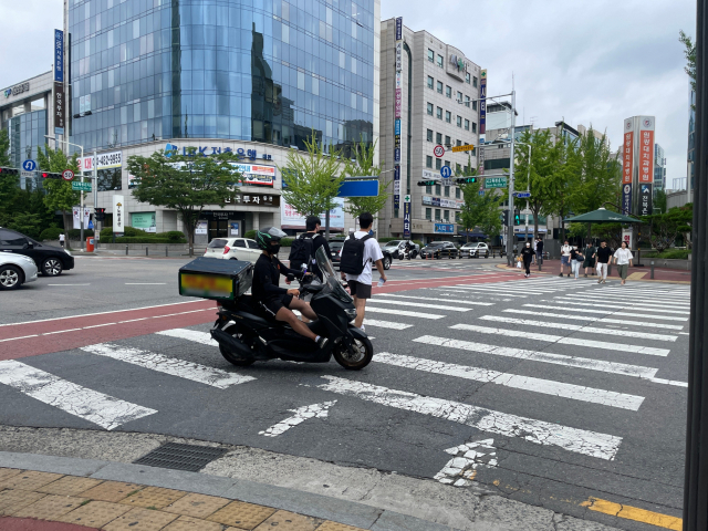 12일 오전 대전 서구 둔산동 시교육청네거리에서 한 오토바이가 횡단보도를 건너는 시민들을 무시한 채 우회전하고 있다. 사진=김성준 기자