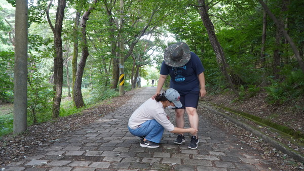 지난 5일 대전 서구 도솔산을 오르던 중 발달장애인 이지영(19‧왼쪽) 양의 신발끈이 풀리자 어머니 성경미(46) 씨가 묶어주고 있다. 사진=김성준 기자