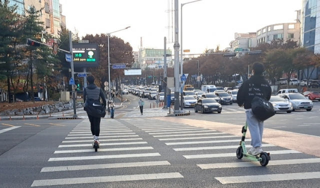 17일 대전 서구 둔산동 큰마을네거리에서 시민들이 보호구를 착용치 않은 채 전동킥보드를 타고 있다. 사진=장심결 기자
