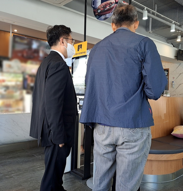 ▲ 17일 오전 대전시청 인근 카페에서 한 노인이 남성이 도움을 받아 키오스크에서 주문하고 있다. 사진=장심결 수습기자