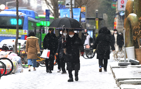 눈이 내린 26일 대전 서구 둔산동에서 시민들이 눈을 맞으며 발걸음을 옮기고 있다. 이경찬 기자