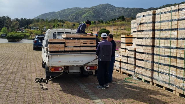지난 14일 서산시가 인지면 희망공원에서 지역 양봉농가의 경영 안정 지원을 위해 양봉기자재 지원사업을 펼치고 있는 가운데 직원들이 한 농민에게 물품을 나눠주고 있다. 서산시 제공