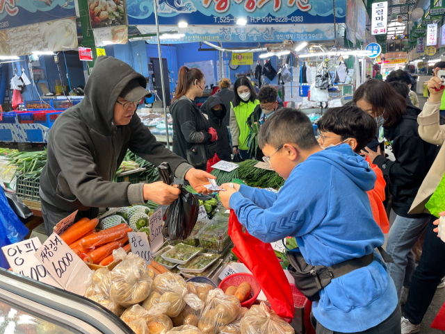 26일 대전도마큰시장을 찾은 대전산서초등학교 학생이 직접 물건을 구매하고 거스름돈을 받고 있다. 사진=한유영 기자
