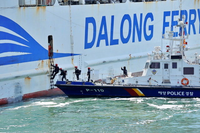 여객선으로 접안을 시도하는 평택해양경찰서 P-110정에서 구조대원이 등선을 하고있다. 사진=평택해경 제공
