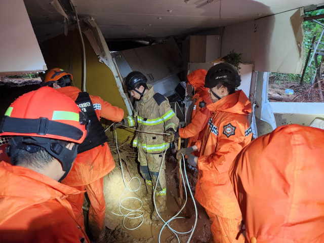15일 오전 소방대원들이 충남 청양 정산면 해남리의 한 주택에서 토사에 매몰된 60대 여성을 구조하고 있다. 충남소방본부 제공
