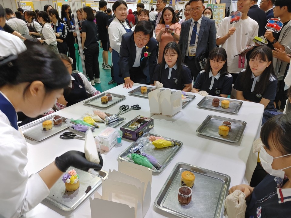 ‘꿈꾸세(종) 직업교육 축제’를 찾은 최교진 세종시교육감이 세종장영실고 외식조리과 ‘나만의 컵케이크 만들기’ 체험 부스에서 학생들을 격려하고 있다. 사진=강대묵 기자
