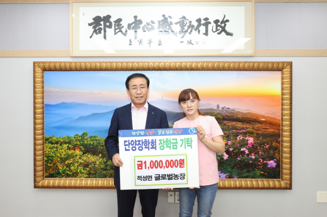박설화 글로벌농장 대표가 김문근(좌측) 단양군수에게 지역 인재육성을 위해 사용해 달라며 단양군장학회에 100만원을 기탁했다. 단양군 제공