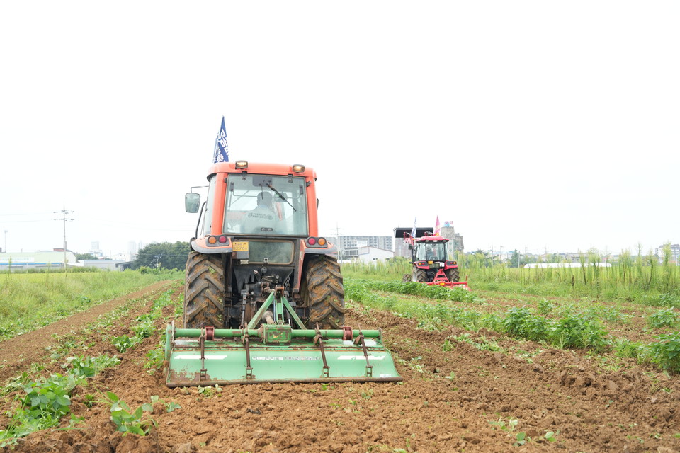 28일 충남 예산 궁평리의 한 논에서 트렉트 등 농기계들이 심어진 콩을 갈아엎고 있다. 김중곤 기자