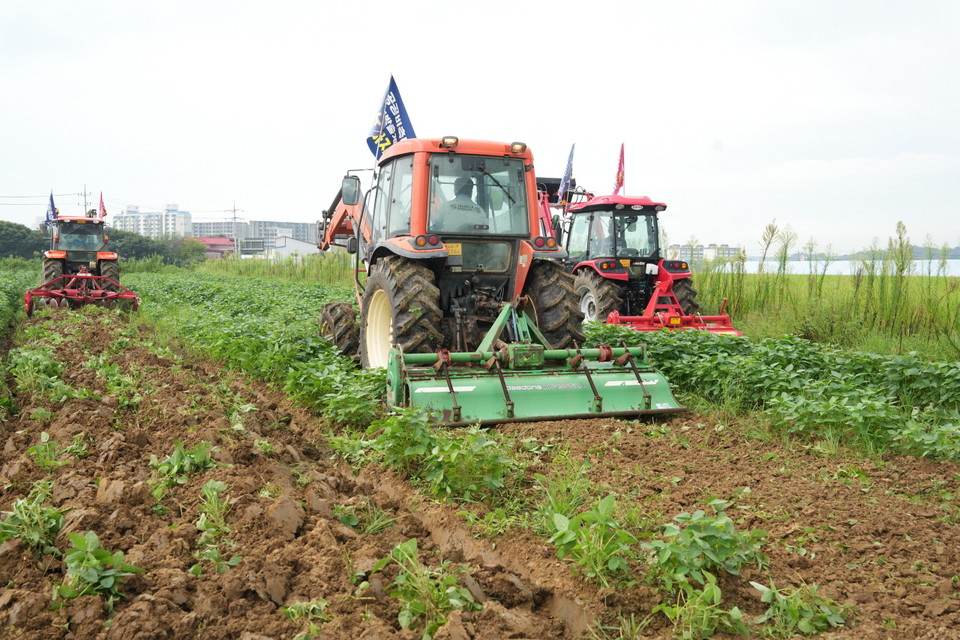 28일 충남 예산 궁평리의 한 논에서 트렉트 등 농기계들이 심어진 콩을 갈아엎고 있다. 김중곤 기자
