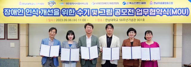 6일 한남대학교 56주년 기념관에서 대전시사회서비스원과 5개 기관이 장애인 인식 개선 ‘2023년 수기 및 그림 공모전’ 개최를 위한 업무협약을 체결했다.(사진 좌측 부터) 김철회 한남마중물협동조합 이사장, 양수연 대덕구청 청년벙커 센터장, 원구환 한남대학교 LINC 3.0사업단 단장, 김현기 대전장애인단체총연합회 사무처장, 김인식 대전시사회서비스원장, 한성일 목요언론인클럽 회장. 대전시사회서비스원 제공