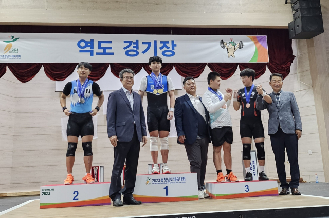 역도 73kg에서 3관왕을 차지한 김주원 선수(가운데)가 시상대에서 기념 사진을 찍고 있다. 사진= 금산중