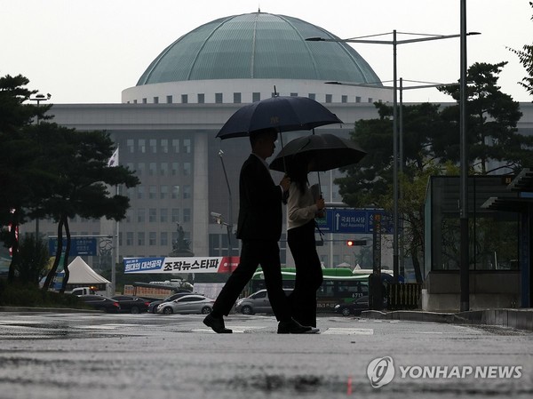 비가 내리는 지난달 20일, 시민들이 국회 앞을 걸어가고 있다. 사진=연합뉴스 제공