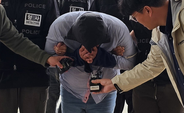 70대 택시 기사를 살해하고 태국으로 도주한 혐의를 받는 40대 남성이 24일 오전 충남 아산경찰서로 압송되고 있다.  사진=연합뉴스