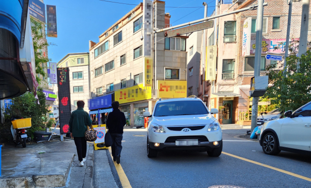 10일 대전 서구 갈마동의 한 도로를 주민들이 아슬아슬하게 걷고 있다. 사진=김성준 기자