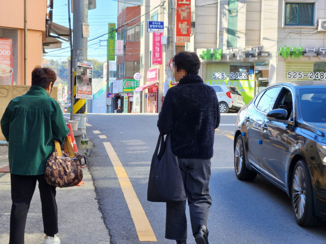 10일 대전 서구 갈마동의 한 도로를 주민들이 아슬아슬하게 걷고 있다. 사진=김성준 기자