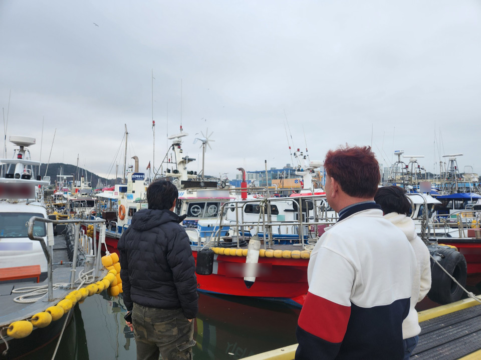 ▲ 편도남 씨(왼쪽에서 두 번째)와 그의 동료들이 충남 보령 대천항에 정박돼 있는 어선들을 보고 있다. 사진=김지현 기자