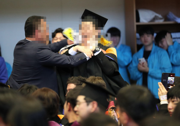 16일 대전 유성구 카이스트(KAIST)에서 열린 2024년 학위수여식에서 한 졸업생이 소란을 피워 경호원들로부터 제지를 당하고 있다. 대전충남사진공동취재단