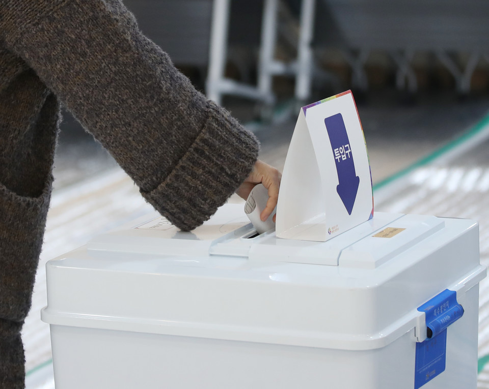 투표소에서 유권자가 투표용지를 투표함에 넣고 있다. 사진=연합뉴스.