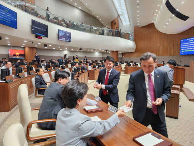 충남도의회 의원들이 충남학생인권조례 폐지 조례안 재의의 건 표결을 위해 종이 투표용지를 받고 있다. 사진=김지현 기자