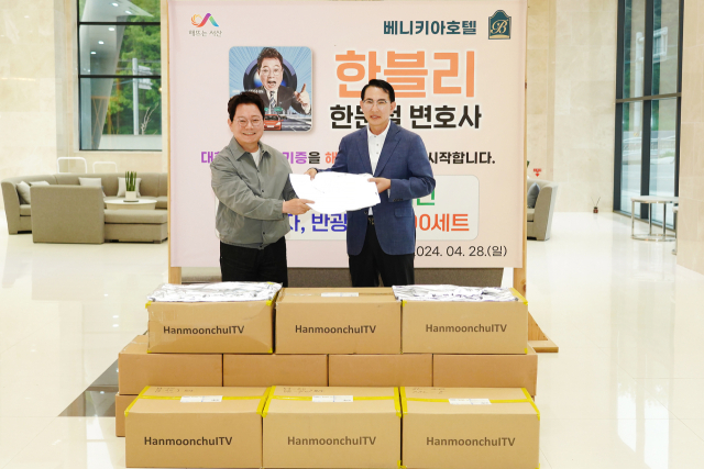 한문철 변호사가 28일 서산 베니키아 호텔에서 이완섭 서산시장과 반광 의류 기증하는 모습. 서산시 제공