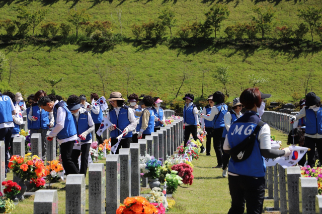 MG탄동새마을금고 임직원과 MG봉사회원, 탄마산악회원 등이 16일 국립대전현충원에서 태극기 꽂기와 묘역 정화활동을 진행하고 있다. 탄동새마을금고 제공