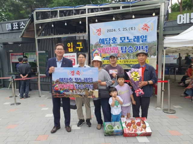 도중선 예산부군수(왼쪽)와 예당호 모노레일 50만번째 방문객 채용병 씨(천안) 가족이 기념촬영을 하고 있다. 예산군 제공