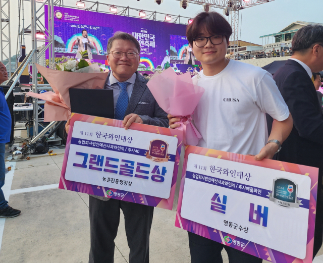 예산사과와인(주) 정제민 대표(왼쪽)가 제11회 한국와인대상에서 그랜드골드상과 실버상을 수상하고 기념촬영을 하고 있다. 예산군 제공