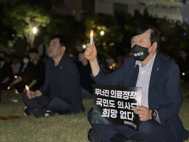 30일 오후 8시 대전 서구 보라매공원에서 진행된 ‘대한민국 의료 사망선고 촛불집회’에서 한 참가자가 전자 촛불을 들고 있다. 사진=함성곤 기자.