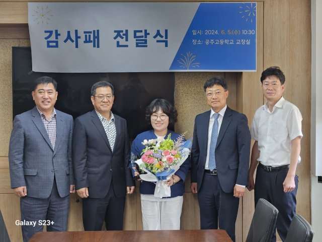 공주고 교장실에서 열린 감사패 전달식에서 이희국 방경화 부부(왼쪽에서 두번째)가 축하의 꽃다발을 받고 있는 모습.사진=김익환 기자