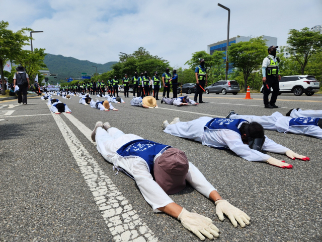 14일 충남장애인부모회 관계자들이 충남도청 앞에서 오체투지를 하고 있다. 사진=김지현 기자