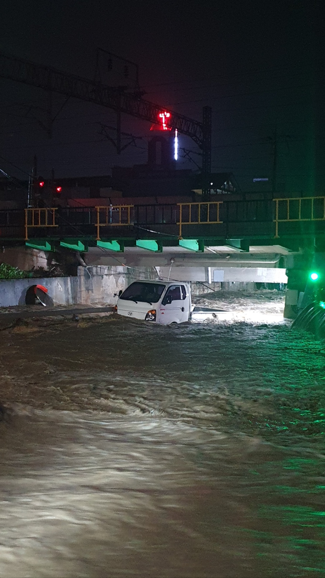옥천군에 내린 많은 비로 8일 옥천읍 양수리 금구천에는 하천이 범람해 주차 되어있던 트럭이 침수돼 차량을 이동 조치했다.(사진/옥천소방서 제공)