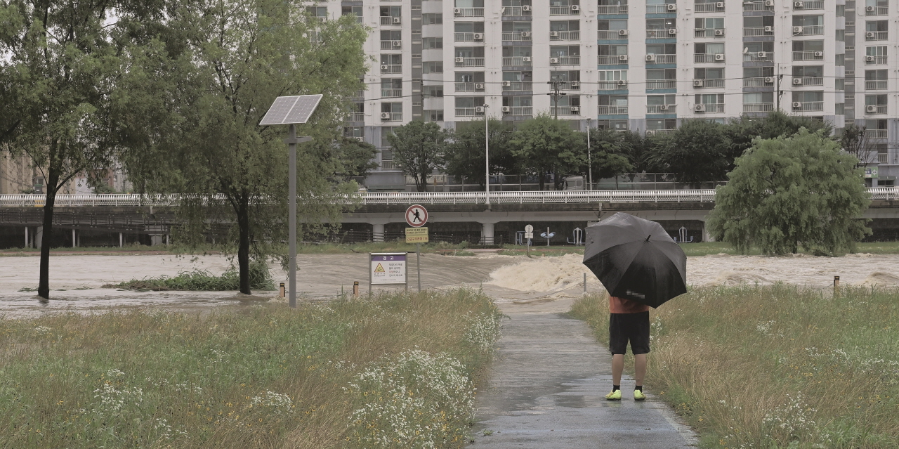 장맛비가 내린 8일 우산을 쓴 시민이 집중호우로 인해 물에 잠겨있는 대전 중구 유등천 일대를 지켜보고 있다. 김주형 기자 hyoung99.cctoday.co.kr