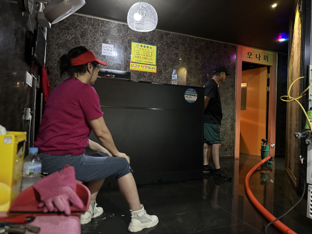 10일 오전 대전에 내린 집중 호우로 인해 대전 서구 정림동의 한 상가 지하에 위치한 노래방에 물이 들이닥쳤다. 노래방 주인이 양수기 펌프가 연신 물을 빼내는 모습을 허탈하게 앉아 지켜보고 있다. 사진=함성곤 기자.