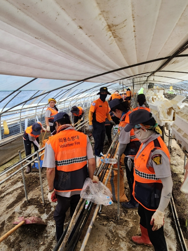 ▲충남의용소방대 연합회원들이 논산시 가야곡면의 한 수해피해지역에서 토사와 잔해물을 제거하고 있다.