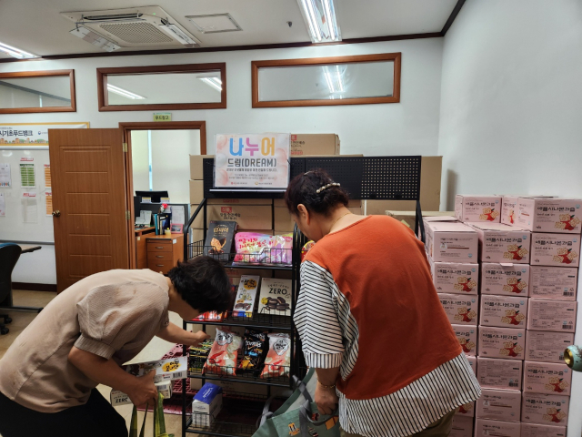 25일 푸드뱅크 이용자들이 충남 서산기초푸드뱅크 매대에서 식료품과 생활용품을 살펴보고 있다. 사진=김지현 기자