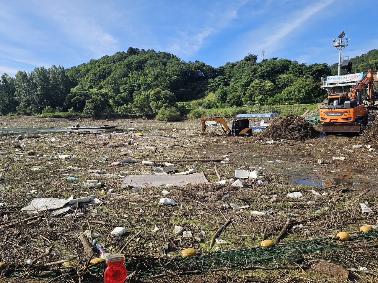 옥천군 군북면 추소리 대청호에서 7일 장맛비에 떠내려 온 쓰레기 수거 작업을 하고 있다. 옥천=박병훈 기자