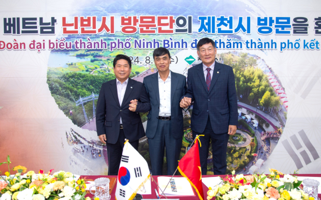 김창규 제천시장과 딘반트 베트남 닌빈시 시장 등 방문단이 2025제천국제천연물산업엑스포 성공개최를 위한 사업설명회를 갖고 있다. 사진은 김창규(좌측) 제천시장과 딘반트(가운데) 베트남 닌빈시 시장, 박영기 제천시의장이 손을 잡고 있다. 제천시 제공