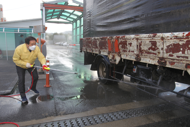 송기섭 진천군수가 가축전염병 방역 현장 일손을 돕는 모습. 진천군 제공
