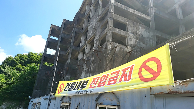 32년째 방치된 계룡산 입구 ‘폐호텔’ 부지에 출입금지를 알리는 현수막이 나부끼고 있다.사진=김익환 기자