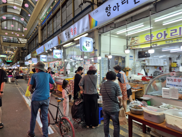 평일 오후 한민시장의 한 반찬가게 손님들이 모여 반찬을 구경하고 있다. 사진=강승구 기자
