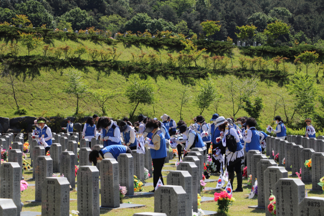지난 5월 진행된 ‘호국보훈의 달 기념 태극기 꽂기 및 묘역정화봉사활동' 현장사진.탄동새마을금고 제공.