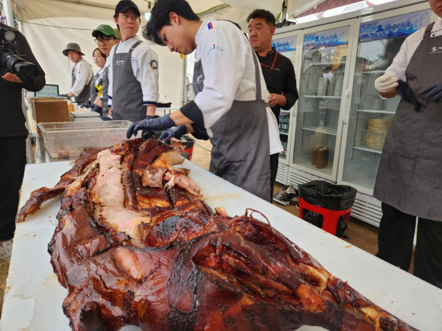 지난해 홍성 바비큐페스티벌에서 통돼지 바비큐를 해체하고 있다. 사진=김지현 기자