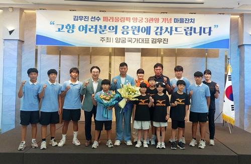 모교인 이원초·이원중 후배들과 기념촬영하는 김우진(가운데) 선수. 사진=연합뉴스 제공