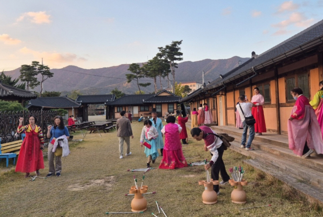 중국인들이 장이익어가는 마을을 찾아 한복을 입고 투호던지기 체험을 하고 있다. 증평군 제공