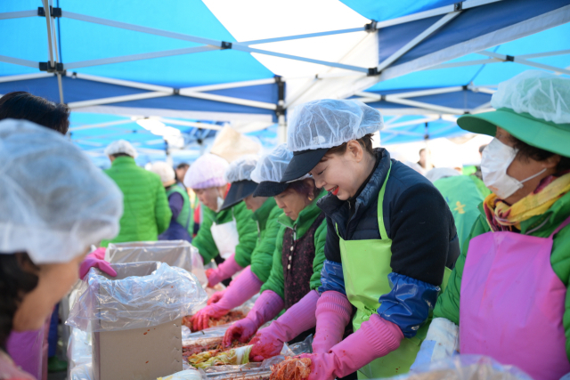 ▲백성현 시장 부인 심재경 여사가 김장 행사에 참여해 정성스럽게 양념을 버무리고 있다. 15년째 김장 나눔에 동참하며 따뜻한 마음을 전하고 있다.