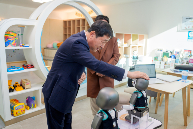이재영 군수가 증평군 청사 내 행복돌봄나눔터에 설치된 인공지능 로봇의 머리를 쓰다듬으며 대화를 나누고 있다. 증평군 제공